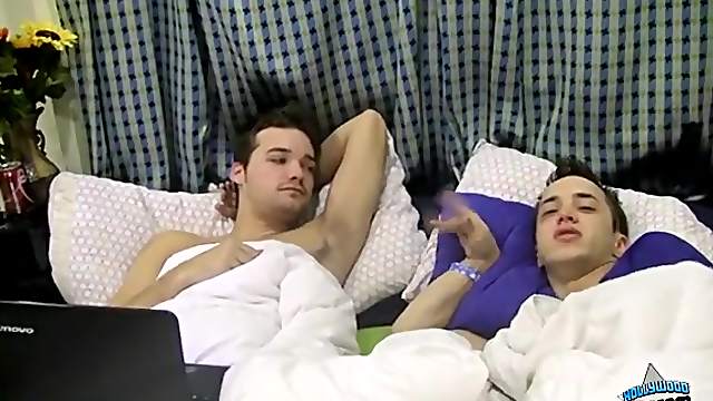 Cute gay couple chats in bed as they wake up