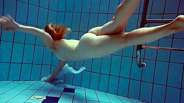 Redhead goes for a nude swim in the pool