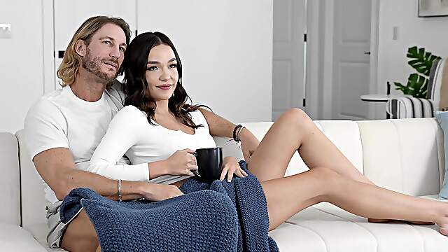 A cute girl is having fun with her boyfriend on the sofa